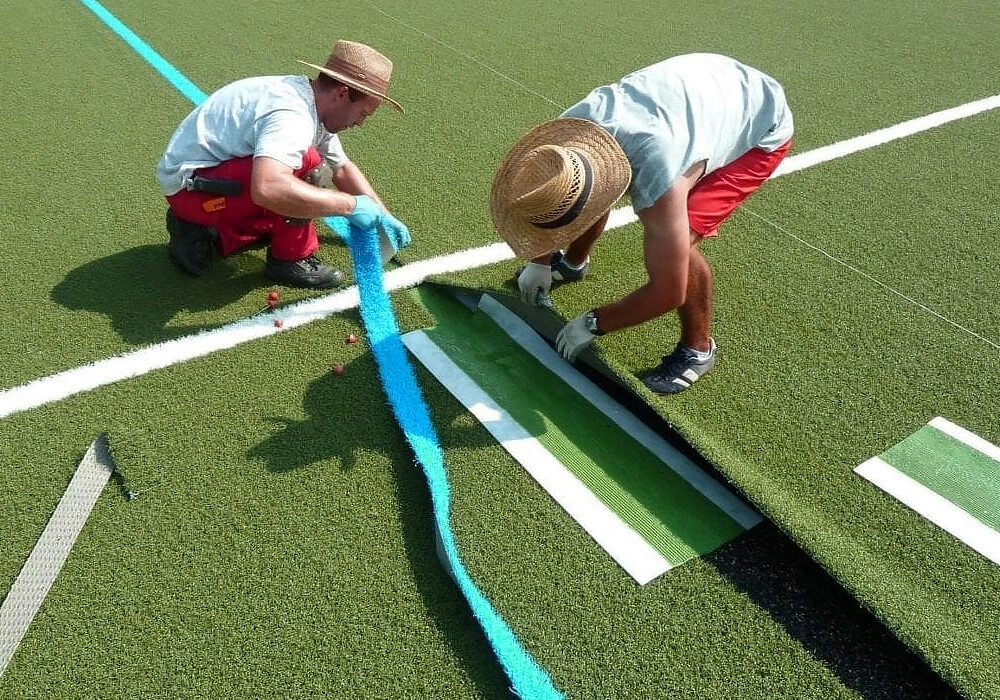 Укладка искусственной травы на футбольное поле с разметкой врезкой